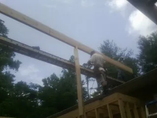 Carpenter setting a ridge beam over a new addition frame — Ice Dam Removal by Roofing Brothers in Lake Winola