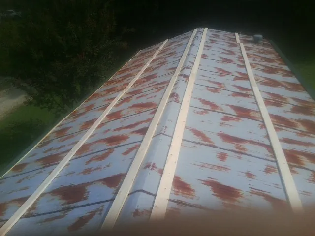 Rusted metal roof panels with new wood purlins before replacement — Storm Damage Roof Repair in Lake Winola by Roofing Brothers