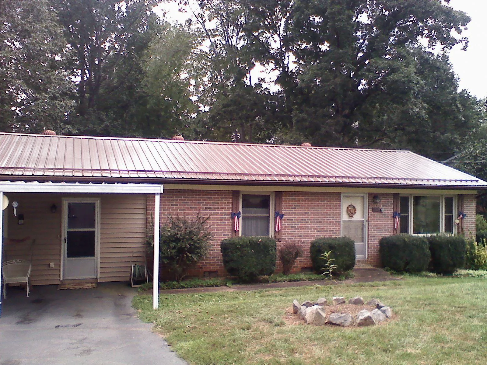 Bronze metal roof and carport on a brick ranch home — Roof Repair work by our crew in Lake Winola
